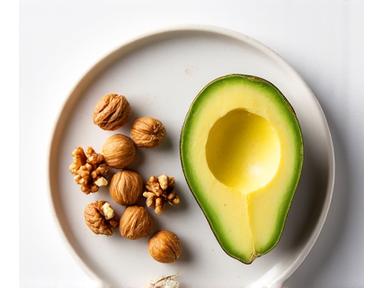 Overhead view of walnuts and avocados, foods beneficial for brain health